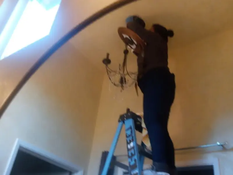 Electrician installing a chandelier in a Wheelersburg residence